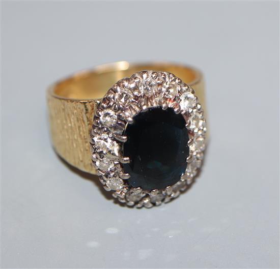 A 1960s textured 18ct gold, sapphire and diamond oval cluster ring, size L.